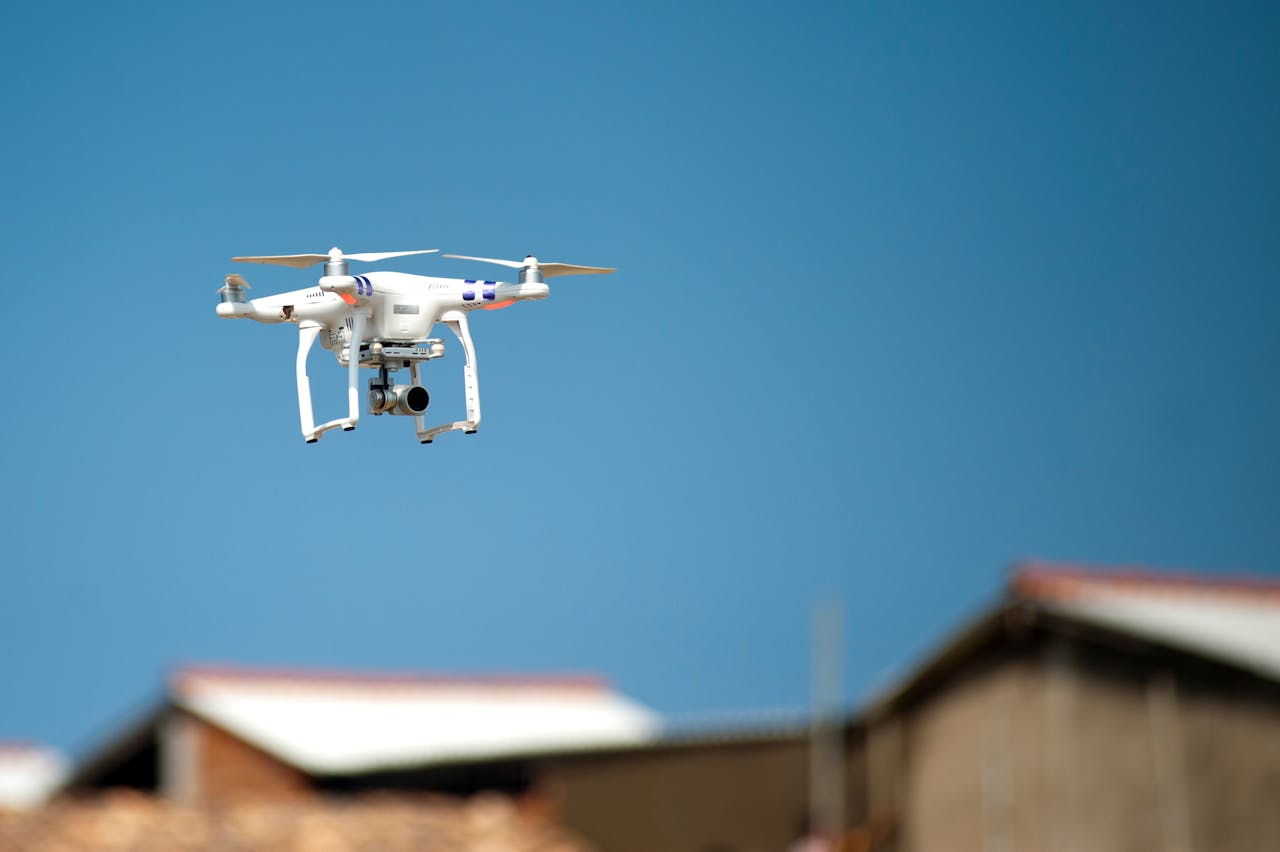 Selective Focus Photograph of White Quadcopter Drone during Blue Hour